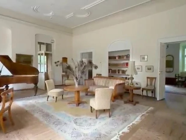 Wohnzimmer mit Flügel und Sitzgruppe Vor der Bearbeitung.